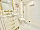 Updated bathroom with white tile, gold fixtures, and marble vanity at 5408 Swift Rd # 28, Sarasota, FL 34231