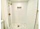 Modern shower with wave patterned tile and pebble floor at 5408 Swift Rd # 28, Sarasota, FL 34231
