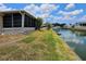 Waterfront backyard featuring a screened-in porch with access to a serene canal at 407 White Oak Way, Sarasota, FL 34237