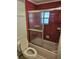 Bathroom featuring a toilet, shower with glass doors, and red tile at 407 White Oak Way, Sarasota, FL 34237