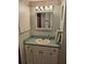 Bathroom featuring a white vanity, mint green counter, and mirrored medicine cabinet at 407 White Oak Way, Sarasota, FL 34237