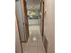 Hallway with tile flooring leads to the kitchen, showcasing an open and inviting layout at 407 White Oak Way, Sarasota, FL 34237