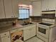 Functional kitchen with stainless steel sink, white cabinetry, and coordinating backsplash at 407 White Oak Way, Sarasota, FL 34237