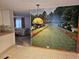 Living room with carpeted floors, large mural, and an archway leading to the kitchen at 407 White Oak Way, Sarasota, FL 34237