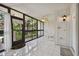Bright, tiled screened porch with white wicker chairs and ceiling fan at 3438 Wood Owl Cir # 275, Bradenton, FL 34210
