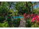 Community pool surrounded by lush tropical foliage at 3438 Wood Owl Cir # 275, Bradenton, FL 34210