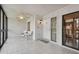 Screened porch with tiled floor, white wicker chairs, and access door at 3438 Wood Owl Cir # 275, Bradenton, FL 34210