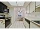 Condo kitchen with white cabinets, tile floor, and stainless steel appliances at 3438 Wood Owl Cir # 275, Bradenton, FL 34210
