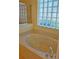 Bathroom with garden tub and glass block window at 7421 Fairlinks Ct, Sarasota, FL 34243