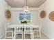 Bright dining room with white table and chairs, wood-paneled ceiling, and coastal decor at 16904 Vardon Ter # 108, Bradenton, FL 34211