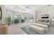 Serene bedroom with tray ceiling, large windows, and comfortable seating area at 7430 Weeping Willow Dr, Sarasota, FL 34241