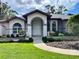 Charming home featuring a welcoming arched entryway, well-manicured landscaping, and inviting curb appeal at 7430 Weeping Willow Dr, Sarasota, FL 34241