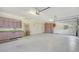 Spacious garage with storage solutions including pink cabinetry and large storage shelving at 7430 Weeping Willow Dr, Sarasota, FL 34241