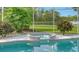 Jacuzzi with tile surround overlooks the serene backyard and water view through the screen at 7430 Weeping Willow Dr, Sarasota, FL 34241