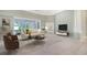 Comfortable living room with neutral tones, fireplace, and screened patio view at 7430 Weeping Willow Dr, Sarasota, FL 34241
