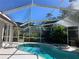 Inviting pool and spa with damaged screen enclosure at 7430 Weeping Willow Dr, Sarasota, FL 34241
