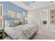 Main bedroom with light blue accent wall and a view to the bathroom at 7336 Haddington Cv, Bradenton, FL 34202