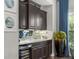 Home bar with dark wood cabinets, granite countertop, and wine cooler at 7336 Haddington Cv, Bradenton, FL 34202