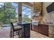 Outdoor kitchen with stone accents and stainless steel appliances at 7336 Haddington Cv, Bradenton, FL 34202