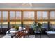 Bright sunroom with glass windows, rattan furniture, and glass-top table at 1712 Lakeside Dr # 1712B, Venice, FL 34293