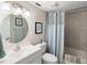 Clean bathroom with shower/tub combo, white vanity, and round mirror at 1712 Lakeside Dr # 1712B, Venice, FL 34293
