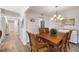 Spacious dining area features a wood table, hardwood floors and an adjacent hallway at 1712 Lakeside Dr # 1712B, Venice, FL 34293