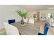 Elegant dining room with a grey table and blue velvet chairs, kitchen view at 14359 Skipping Stone Loop, Parrish, FL 34219