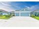 House exterior featuring a light blue three-car garage and landscaping at 14359 Skipping Stone Loop, Parrish, FL 34219