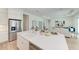Kitchen island with double sink, white cabinets, and a view into the living area at 14359 Skipping Stone Loop, Parrish, FL 34219