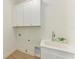Laundry room with white cabinets, sink, and vinyl flooring at 14359 Skipping Stone Loop, Parrish, FL 34219
