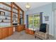 Bright home office with built-in wooden shelving and desk at 15440 County Road 675, Parrish, FL 34219