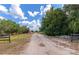 Long gravel driveway leading to a property with mature trees at 15440 County Road 675, Parrish, FL 34219