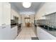 Galley kitchen with stainless steel appliances and tile floor at 15440 County Road 675, Parrish, FL 34219