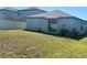 Home's backyard with grass, AC unit and sliding glass door at 15716 Fort Island Pl, Sun City Center, FL 33573