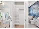 Hallway view into a bathroom with a walk-in shower and closet with open shelving at 1805 Goldenrod St, Sarasota, FL 34239