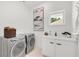 Well-lit laundry room featuring new washer and dryer with folding area at 1805 Goldenrod St, Sarasota, FL 34239