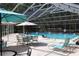 Community pool with seating and umbrellas under a screened enclosure at 1213 Tallywood Dr # 7007, Sarasota, FL 34237
