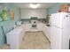 Clean galley kitchen features white cabinetry, appliances, and light flooring at 1213 Tallywood Dr # 7007, Sarasota, FL 34237
