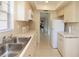 Kitchen with double sink, white cabinets and view to living area at 1213 Tallywood Dr # 7007, Sarasota, FL 34237