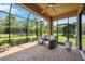 Relaxing screened patio with brick flooring and wicker chairs at 10343 Highland Park Pl, Palmetto, FL 34221