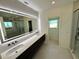 Modern bathroom with double vanity, large mirror, and walk-in shower at 1406 Tangier Way, Sarasota, FL 34239