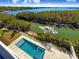 Aerial view of a rectangular pool, spa, boat lift, and lush landscaping at 1406 Tangier Way, Sarasota, FL 34239