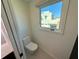 Small powder room with modern toilet and window at 1406 Tangier Way, Sarasota, FL 34239