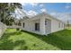 Expansive backyard featuring a covered patio, white fence, and lush green lawn at 1643 35Th St, Sarasota, FL 34234