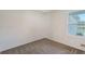 Cozy bedroom showcasing a window, neutral walls, plush carpeting, and a door at 1643 35Th St, Sarasota, FL 34234