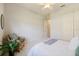 Neutral toned bedroom with a ceiling fan, woven chair and adjacent bathroom entry at 8244 Larkspur Cir, Sarasota, FL 34241