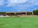 Community clubhouse with putting green and golf cart parking at 7360 Oak Moss Dr # 4, Sarasota, FL 34241