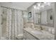Bathroom with granite countertop, shower, and decorative curtain at 4350 Chatham Dr # E307, Longboat Key, FL 34228