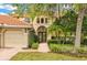 Mediterranean style home with lush landscaping and double doors at 10115 Day Lily Ct, Bradenton, FL 34212