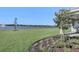 Backyard oasis with lake view, grassy area, and outdoor kitchen at 2605 Waterfront Cir, Sarasota, FL 34240